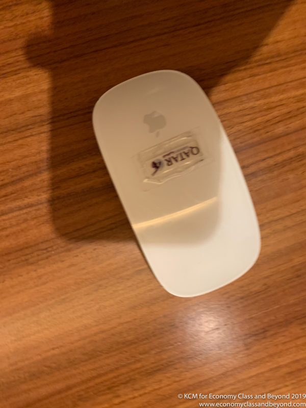 a white computer mouse on a wood surface