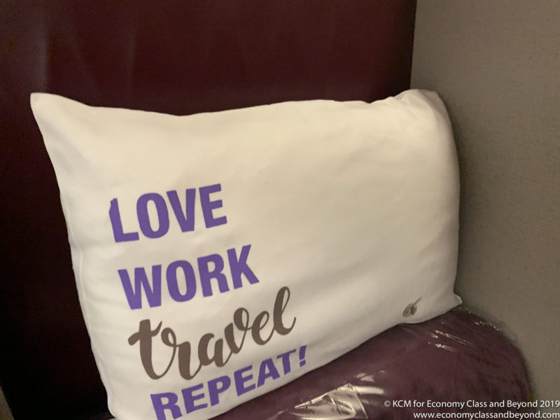 a white pillow with purple text on it