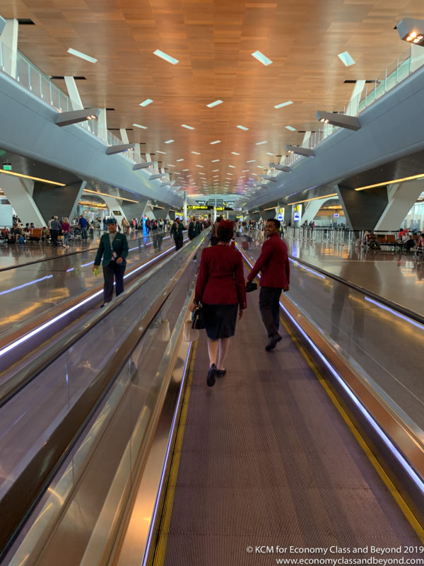 people walking on a walkway in an airport