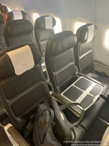 a row of black chairs in an airplane