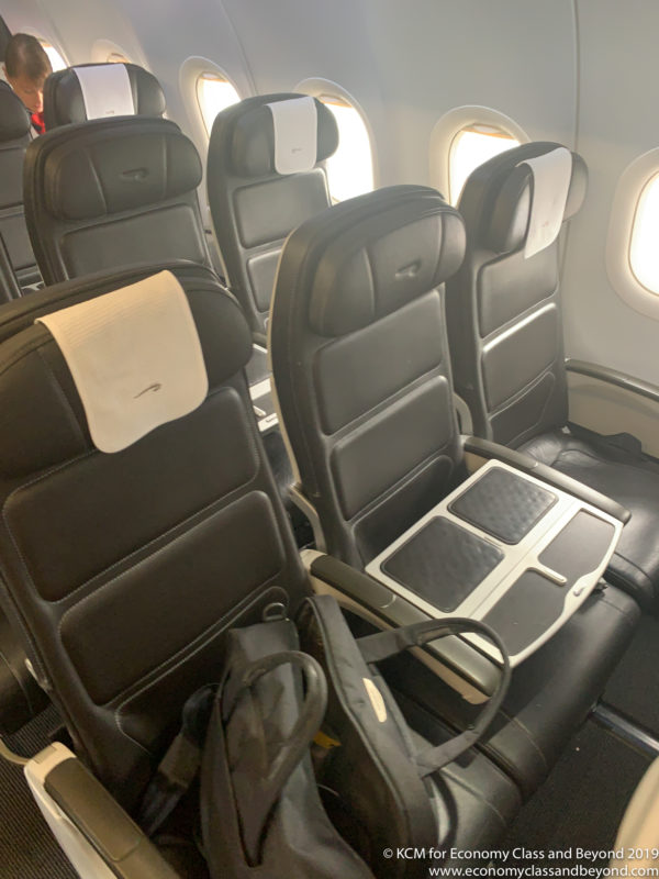 a row of black chairs in a plane