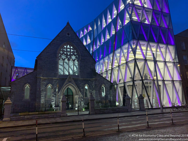 a building with a glass building and a church