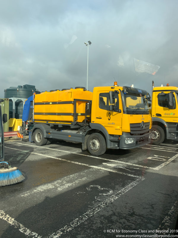 a group of yellow trucks parked in a parking lot