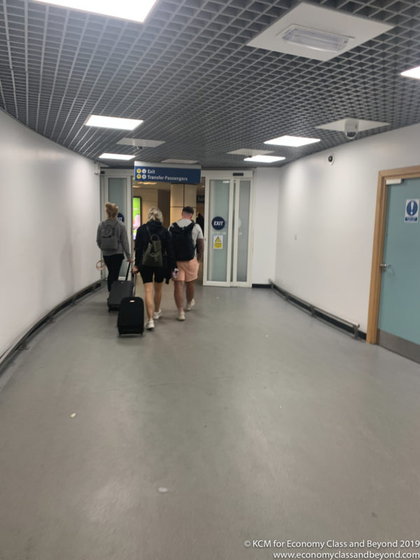 a group of people walking in a hallway with luggage