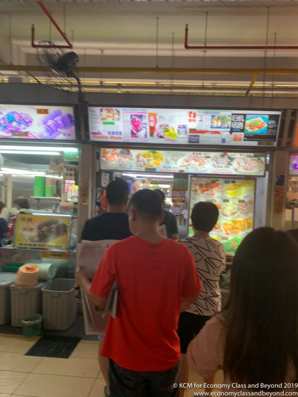 a group of people standing in front of a food kiosk