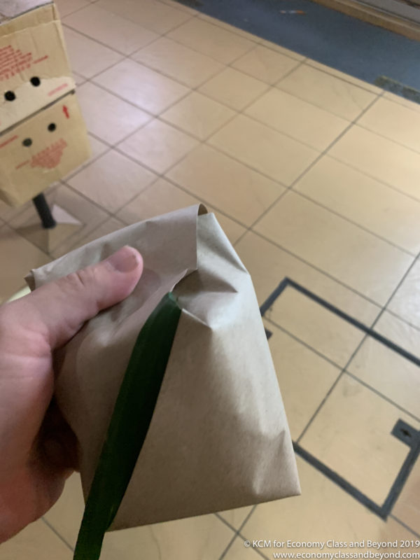 a hand holding a brown bag