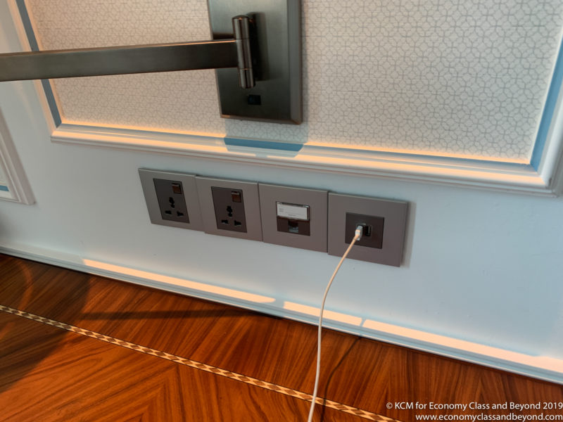 a wall with a power outlet and a wall mounted bar