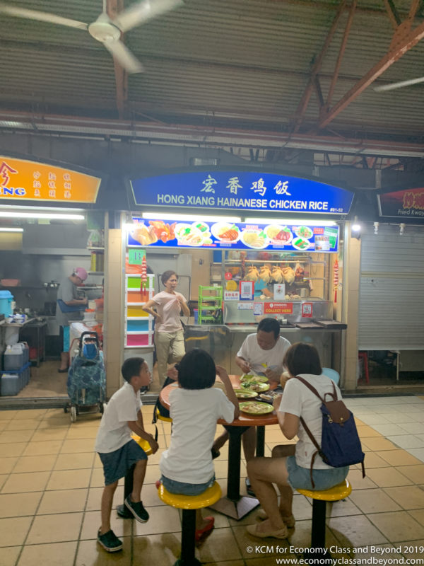 a group of people eating at a food stand