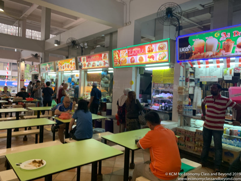 people sitting at tables in a food court