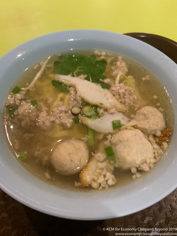 a bowl of soup with meat balls and greens