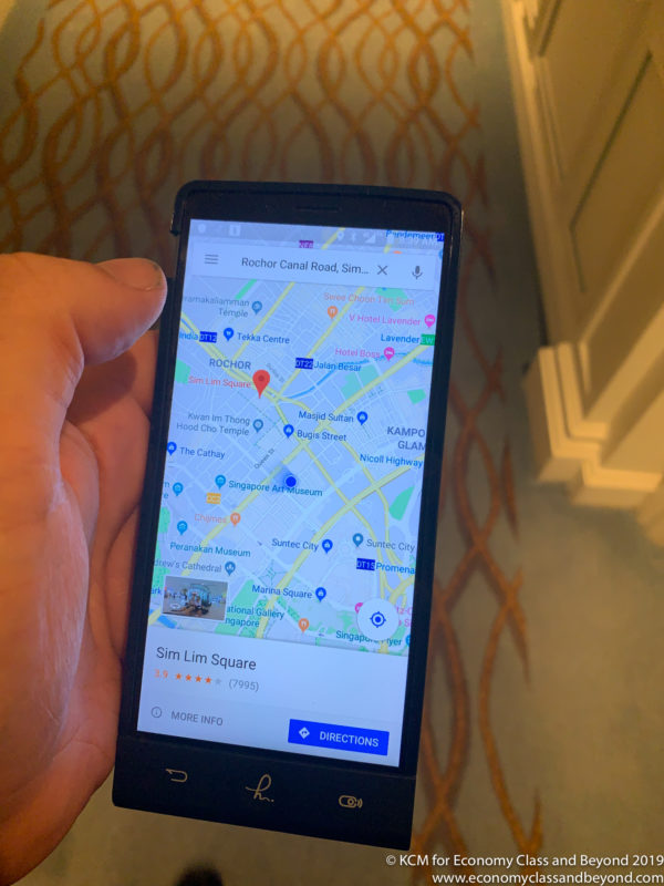 a hand holding a cell phone with a map on the screen