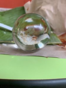 a clear glass ball on a green surface