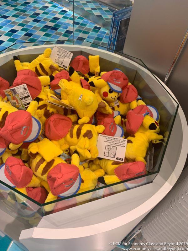 a group of yellow stuffed animals in a glass container