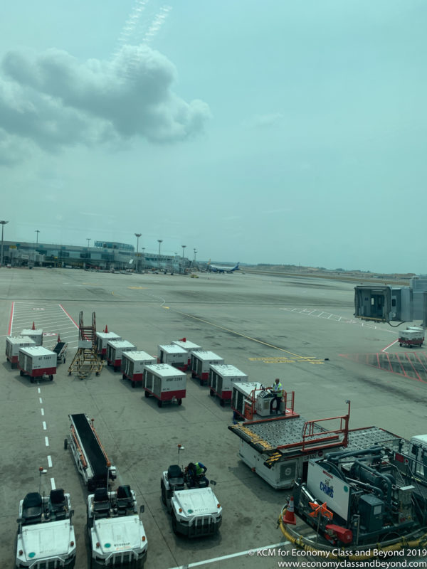 a group of luggage carts on a tarmac