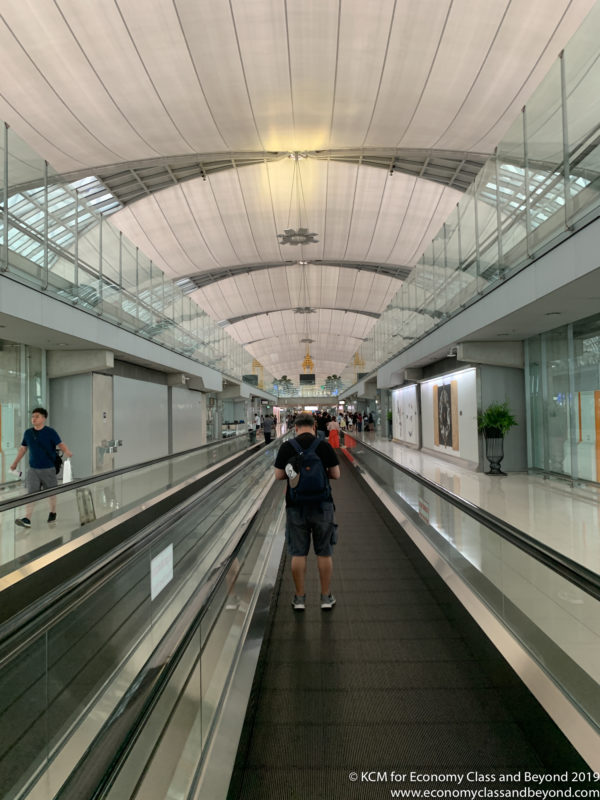 a man walking on a moving walkway in a building