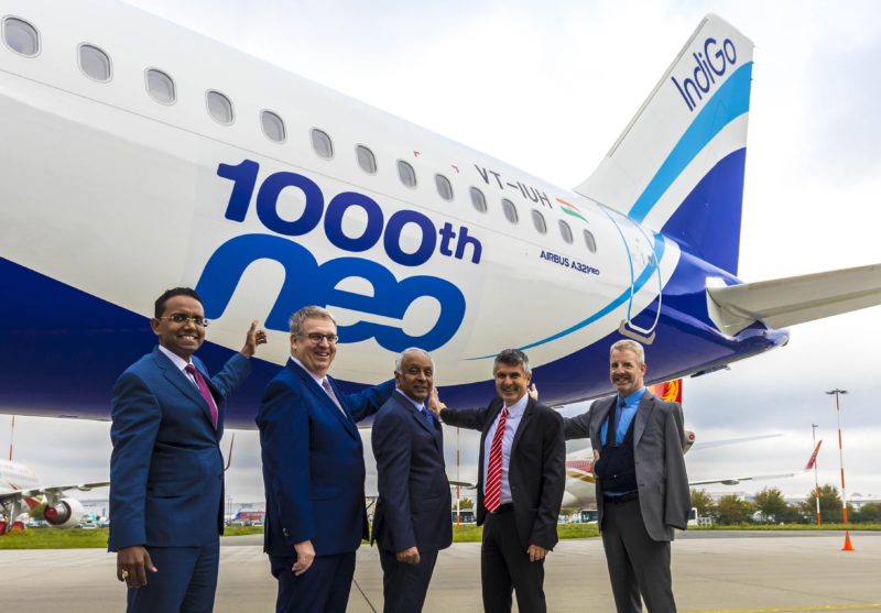 a group of men in suits standing in front of an airplane
