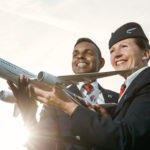 a man and woman holding a model airplane