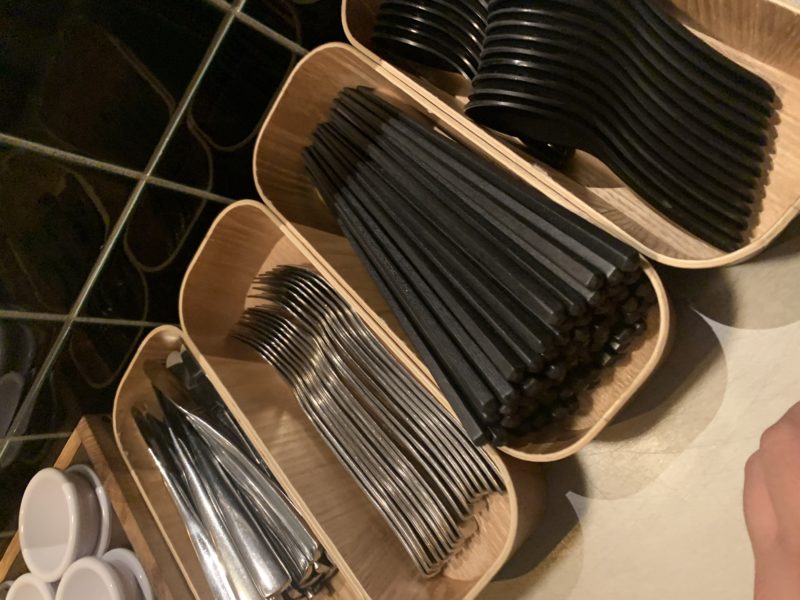 a group of wooden containers with forks and knives