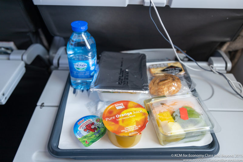 food on a tray with a bottle of water