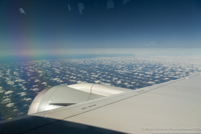 a rainbow over clouds and a plane wing