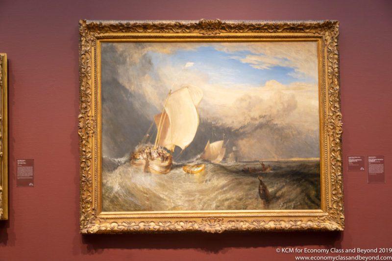 a painting of boats in a gold frame