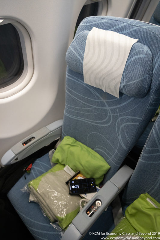 a seat with a phone and a paper towel on it