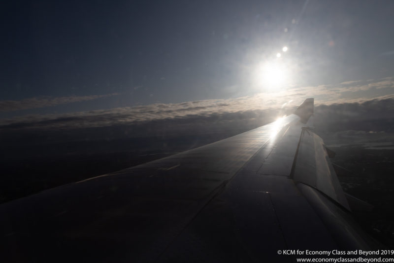 the wing of an airplane with the sun in the background