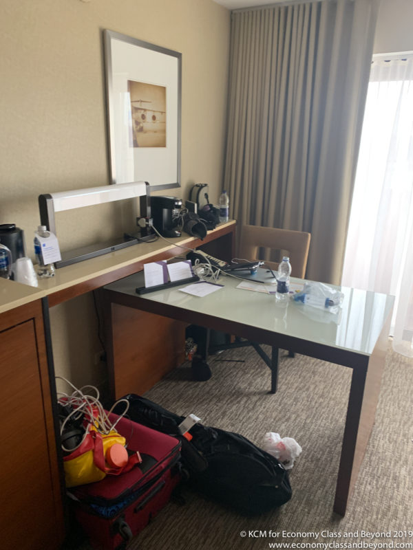 a desk with luggage and a picture on the wall