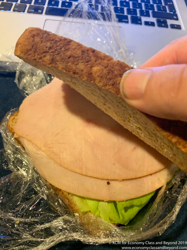 a hand holding a sandwich