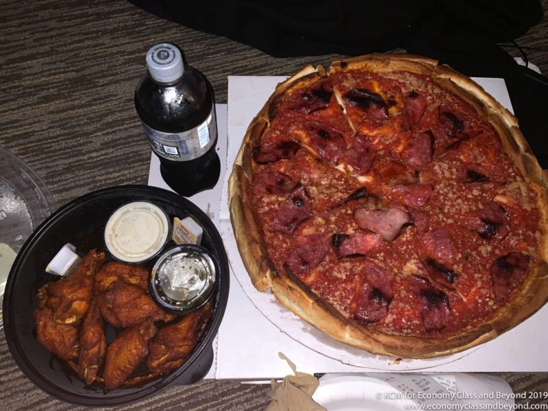 a pizza and chicken wings on a table