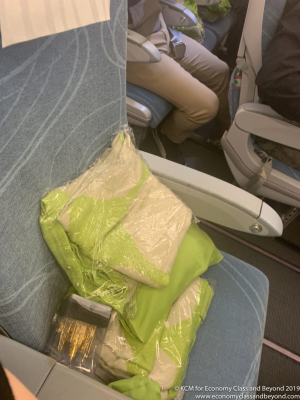 a seat with a bag of clothes and pillows on it