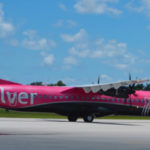 a pink airplane on a runway