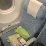 a seat with a green pillow and a white towel on it