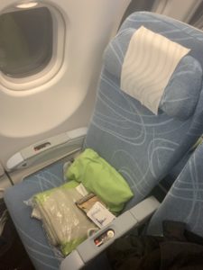 a seat with a green pillow and a white towel on it