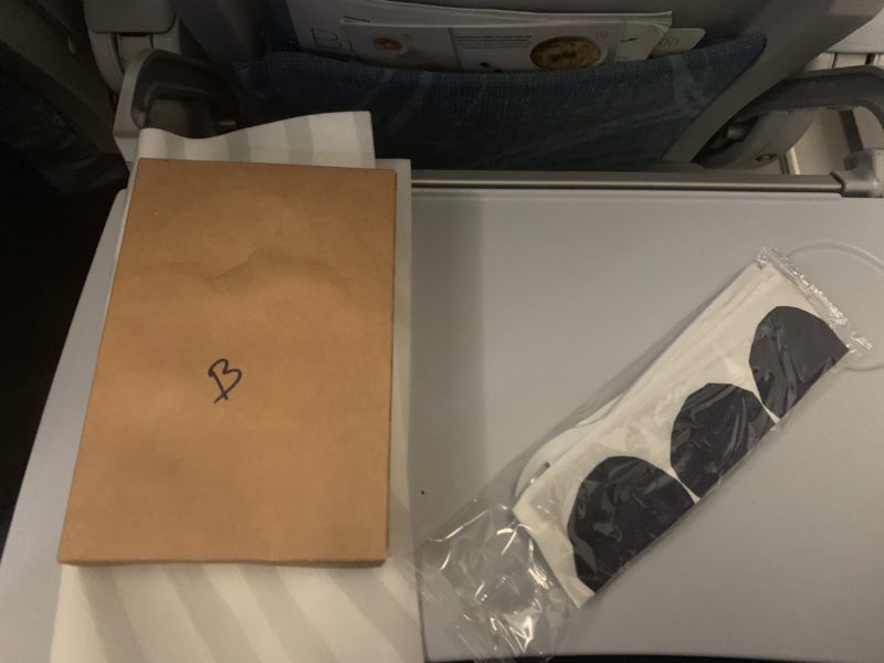 a brown bag next to a white towel and black heart shaped glasses