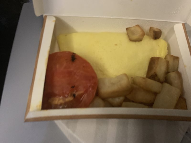 a box of food with a tomato and potato