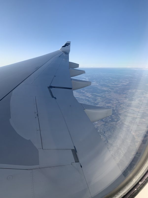 an airplane wing with a view of land below