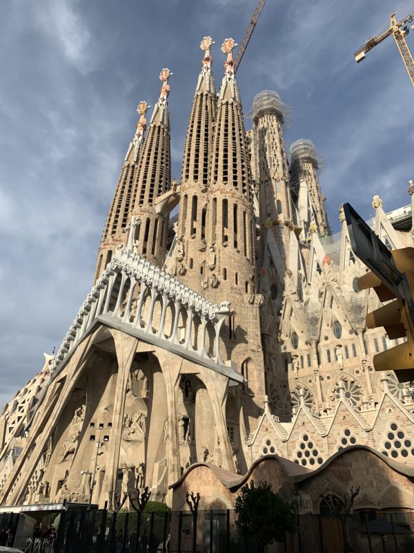 a tall building with towers with Sagrada Família in the background