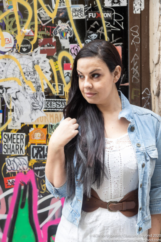 a woman standing in front of a wall with graffiti