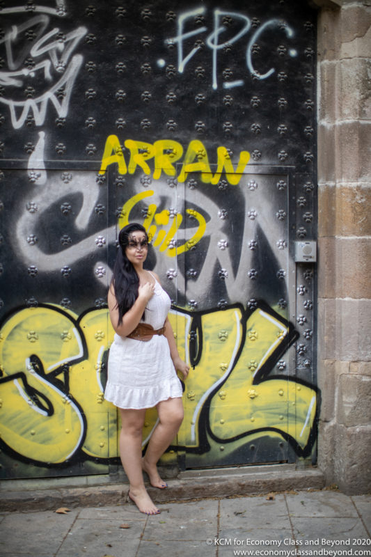 a woman posing in front of a graffiti wall