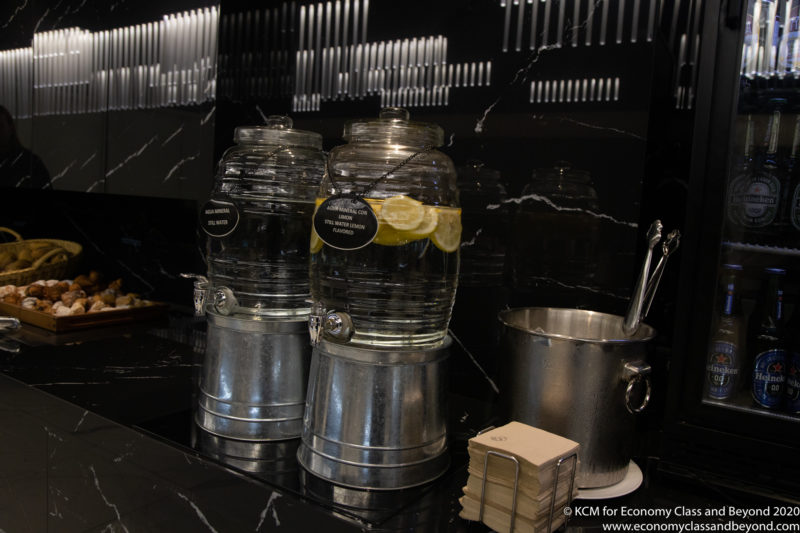 a two large glass containers with lemons on a black counter