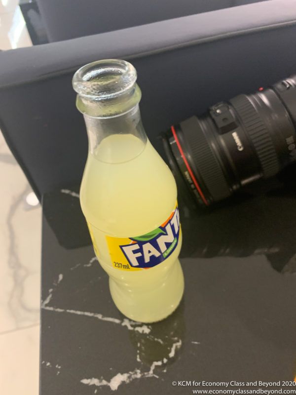 a bottle of soda next to a camera