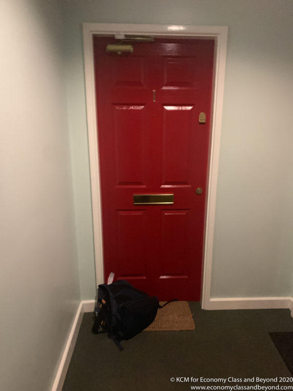 a red door with a backpack on the floor