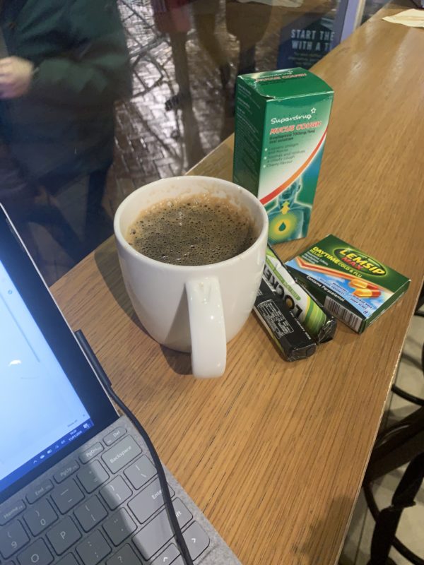 a cup of coffee and some boxes on a table