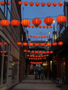 a street with red lanterns from the ceiling