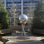 a metal ball sculpture in a courtyard