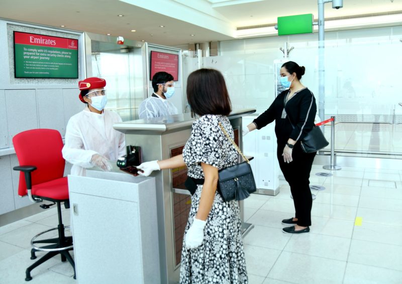 a group of people wearing face masks and standing at a counter