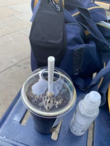 a plastic cup with a straw and a plastic container with liquid in it