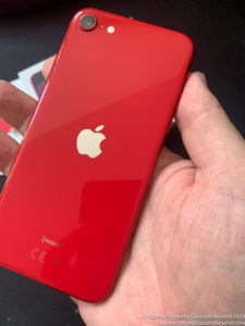 a hand holding a red rectangular device