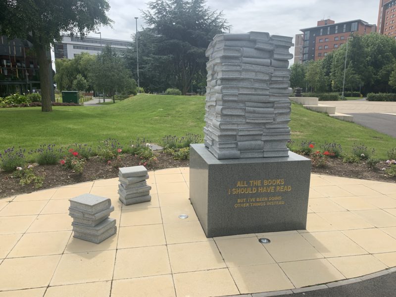 a statue of books on a stone platform